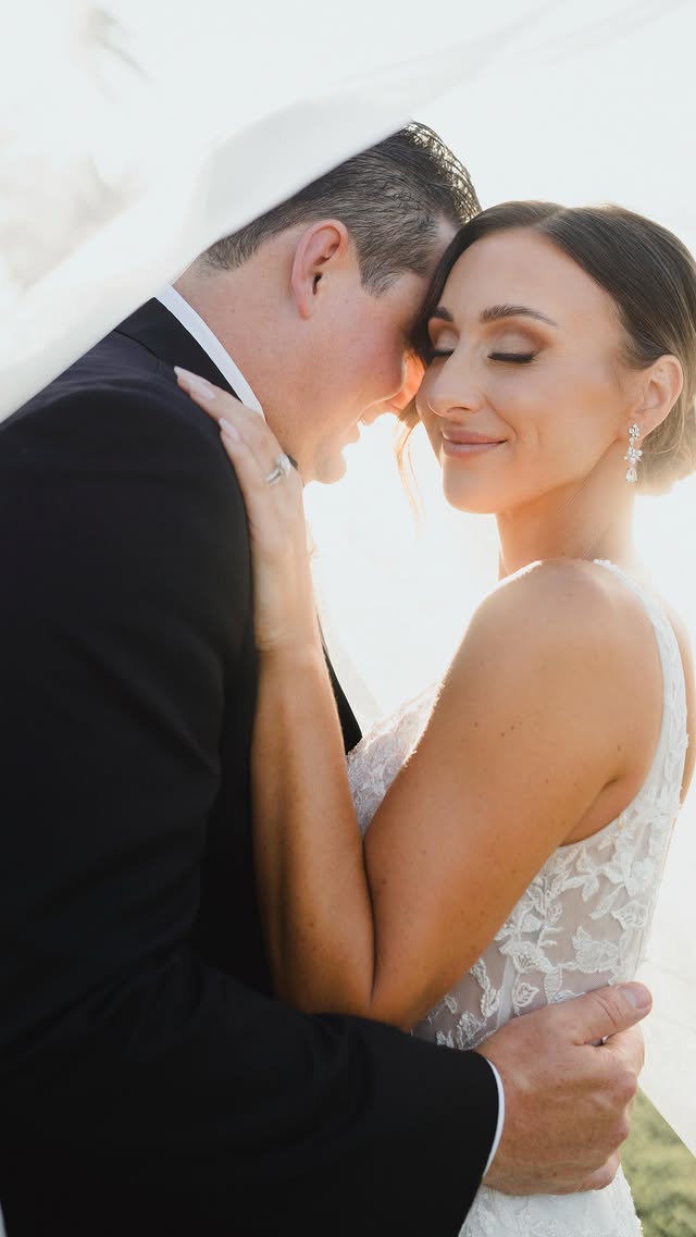 A polished coastal bridal beauty moment in warm natural light.